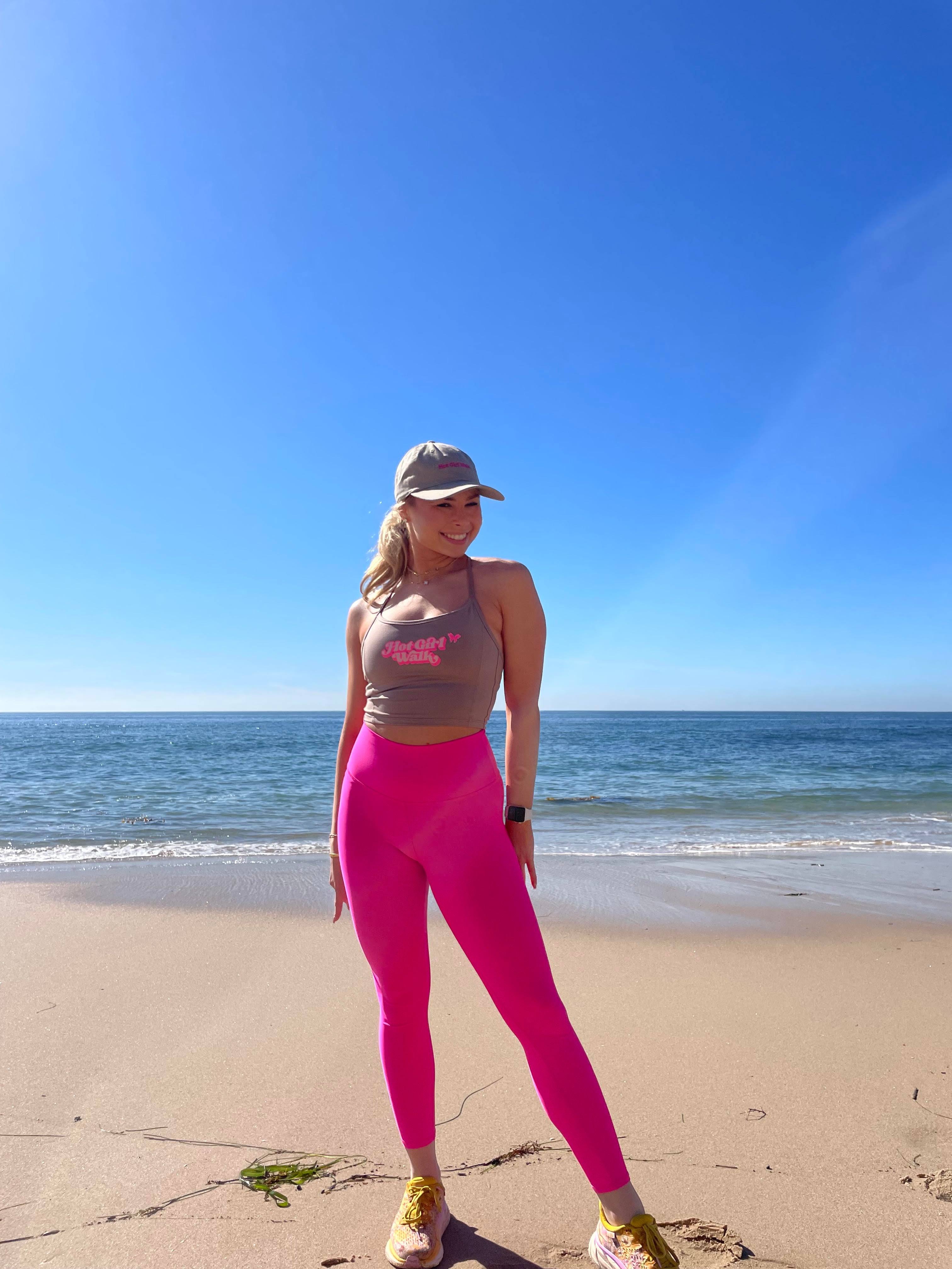 Hot Girl Walk on the beach in southern california. Pink Leggings and Hot Girl Walk workout tank top and Hot Girl Walk Dad Hat.